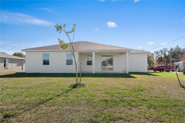 rear view of house featuring a lawn