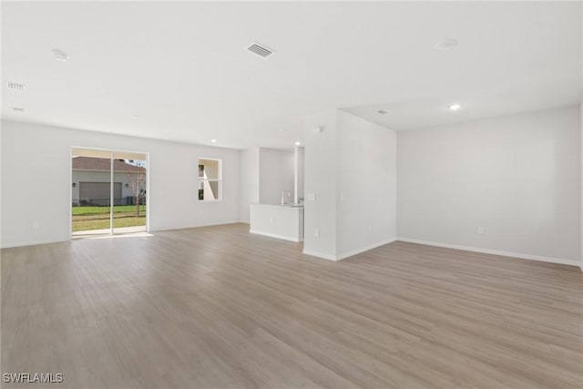 unfurnished living room with light wood-type flooring and sink