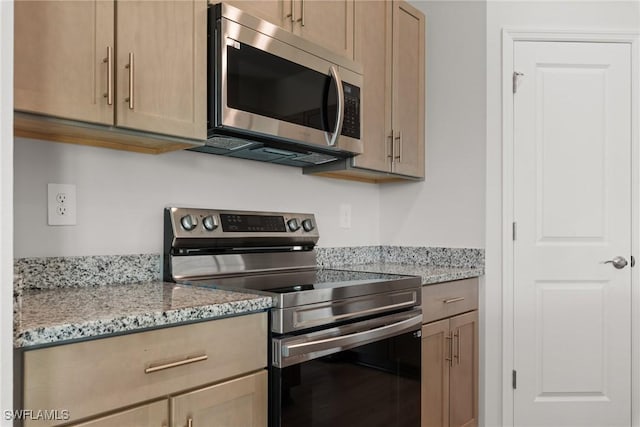 kitchen with light stone countertops, light brown cabinets, and stainless steel appliances