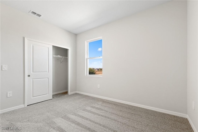 unfurnished bedroom featuring carpet and a closet