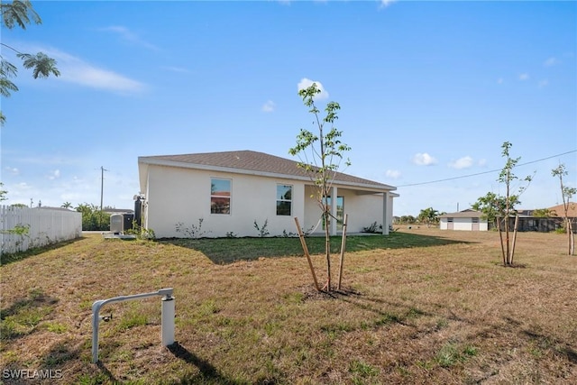 rear view of house featuring a lawn