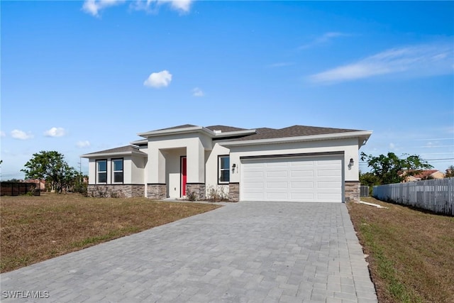 prairie-style house featuring a garage and a front lawn