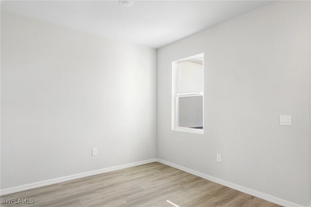 spare room with a wealth of natural light and light hardwood / wood-style flooring