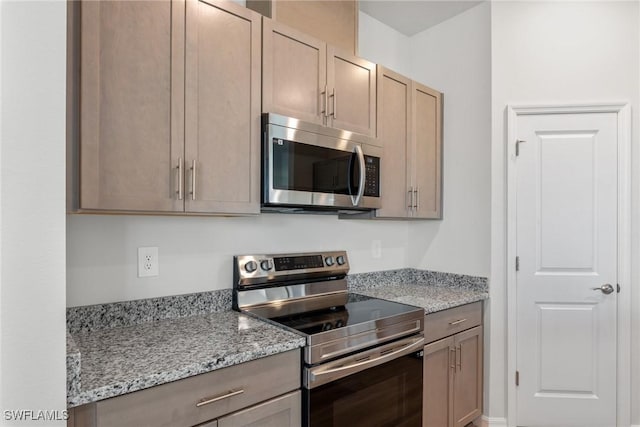 kitchen with light stone counters, light brown cabinetry, and appliances with stainless steel finishes