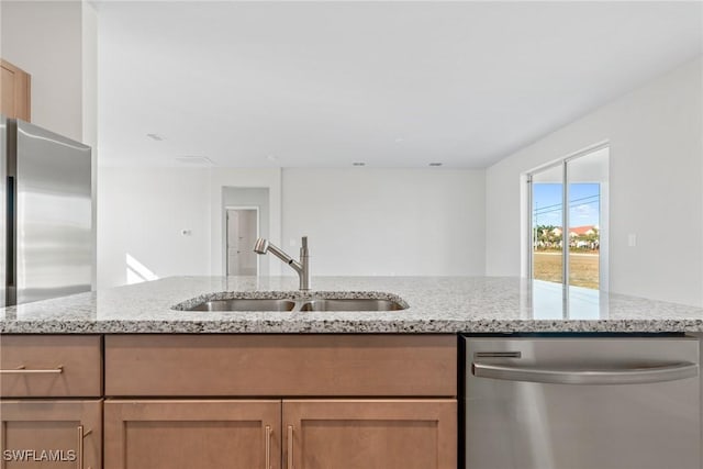 kitchen with dishwasher, sink, and light stone counters