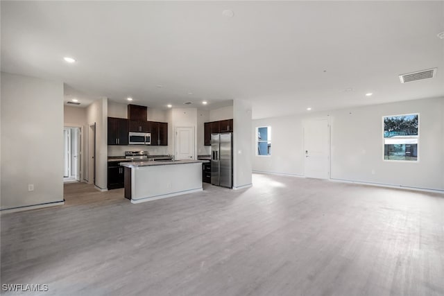 kitchen with a center island with sink, light hardwood / wood-style flooring, and appliances with stainless steel finishes