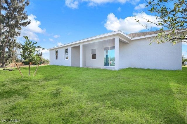 rear view of property with a lawn