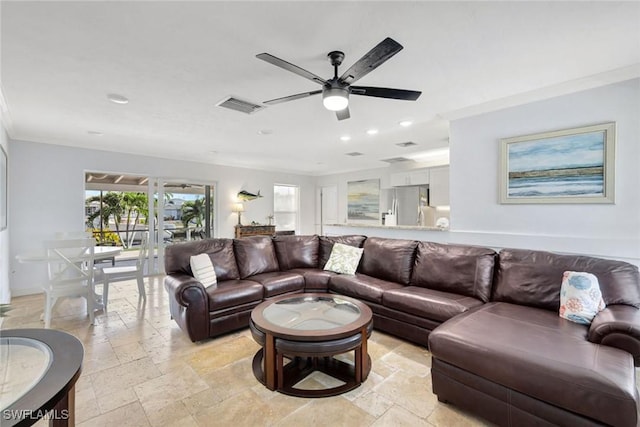 living room with ceiling fan and ornamental molding