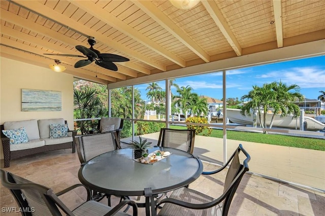 sunroom / solarium with ceiling fan and beam ceiling