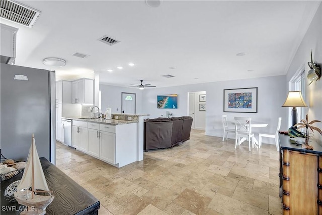 kitchen featuring a wealth of natural light, light stone counters, white cabinets, and stainless steel appliances