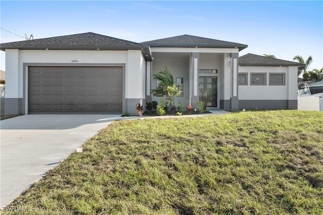 prairie-style home featuring a front lawn and a garage