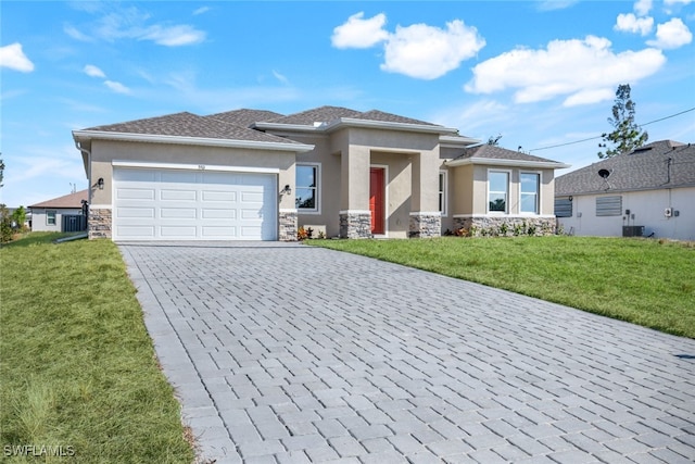 prairie-style house with a front yard, a garage, and central air condition unit