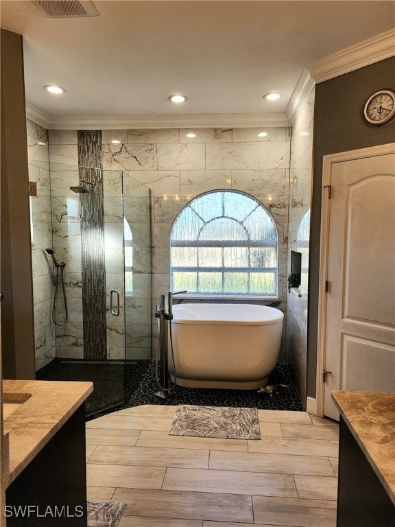 bathroom with vanity, crown molding, and plus walk in shower