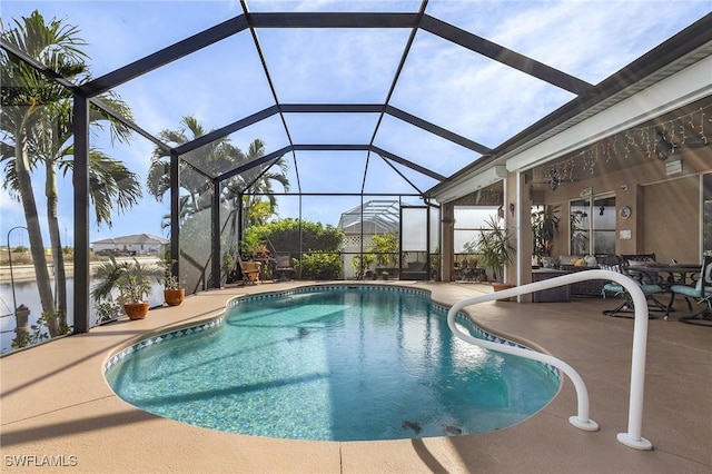 view of swimming pool featuring a patio, a water view, and glass enclosure