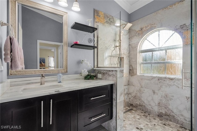 bathroom featuring a tile shower, vanity, and ornamental molding