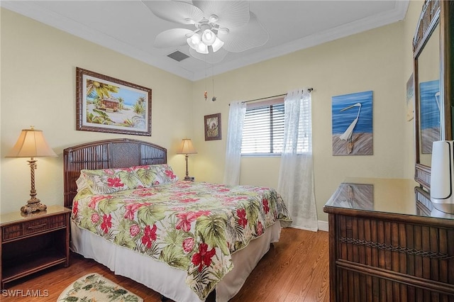 bedroom with ceiling fan, dark wood-type flooring, and ornamental molding