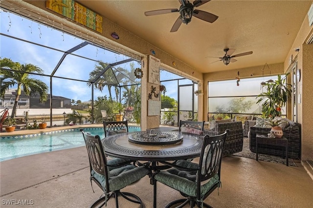 view of patio / terrace featuring glass enclosure, ceiling fan, and an outdoor hangout area