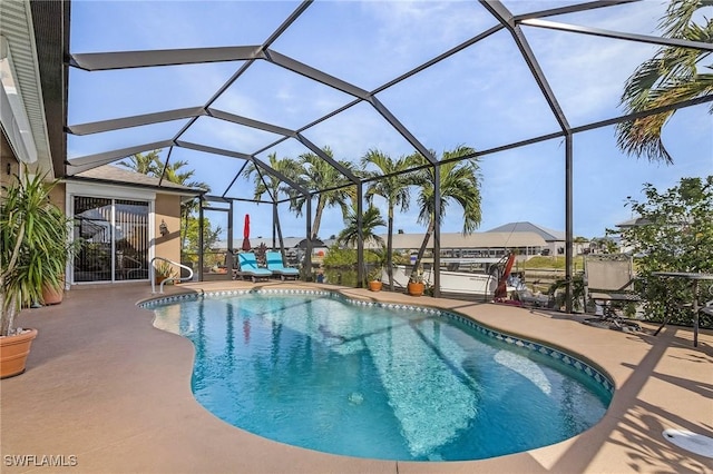 view of pool with glass enclosure and a patio area