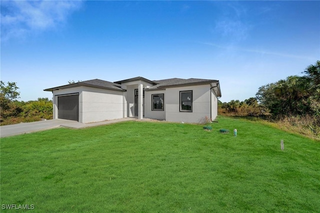 view of front of property with a front yard and a garage