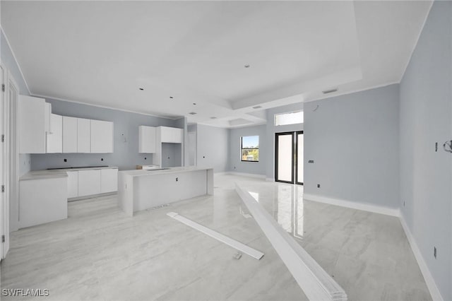 kitchen with white cabinets, a raised ceiling, a kitchen island, and french doors