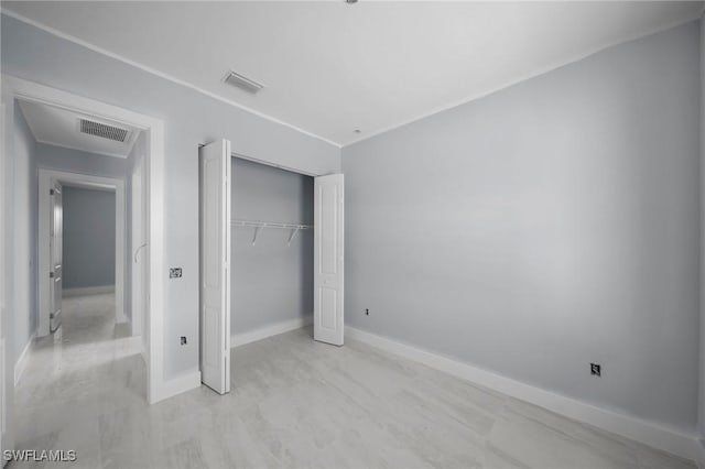 unfurnished bedroom with light wood-type flooring and a closet