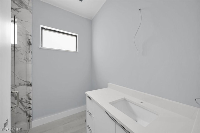 bathroom featuring hardwood / wood-style flooring, vanity, and walk in shower