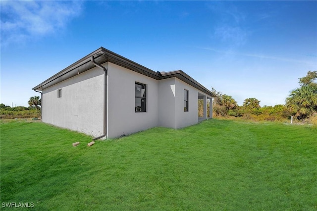 view of side of property with a lawn