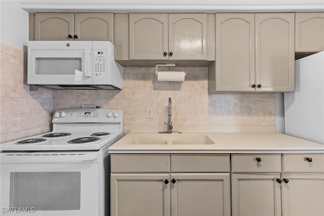 kitchen with decorative backsplash, cream cabinets, white appliances, and sink