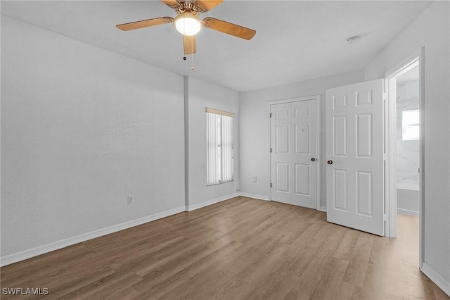 unfurnished bedroom with ceiling fan, light hardwood / wood-style floors, a closet, and multiple windows