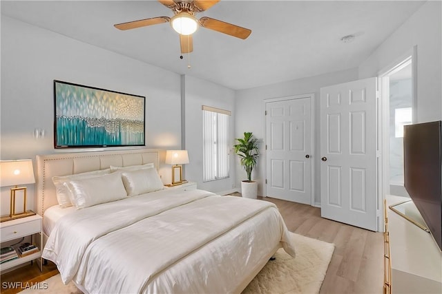 bedroom featuring ceiling fan, a closet, and light wood-type flooring