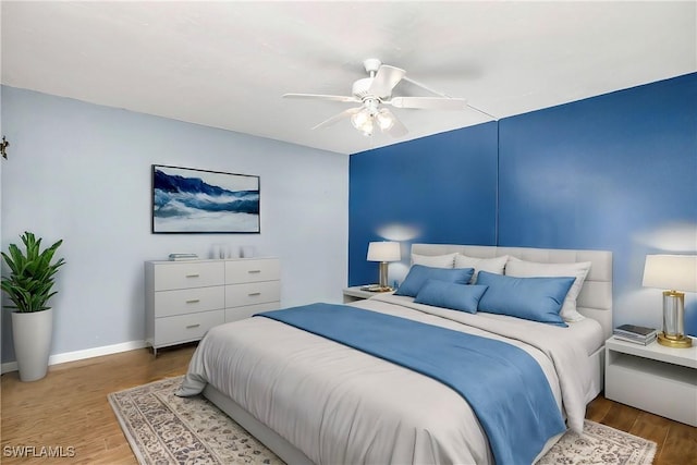 bedroom with ceiling fan and hardwood / wood-style flooring