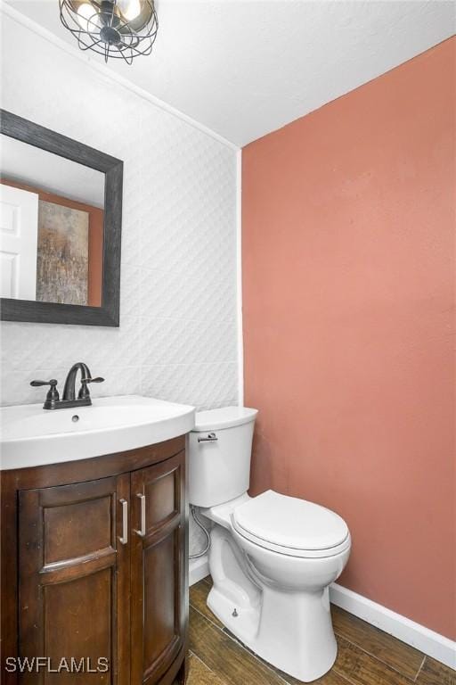 bathroom featuring vanity, wood-type flooring, and toilet