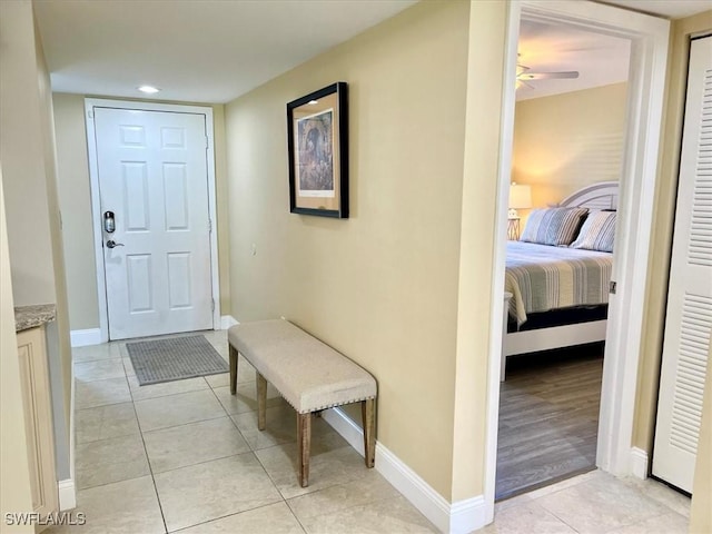 hall with baseboards, light tile patterned floors, and recessed lighting