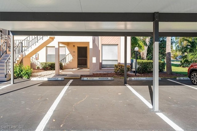 covered parking lot featuring stairs
