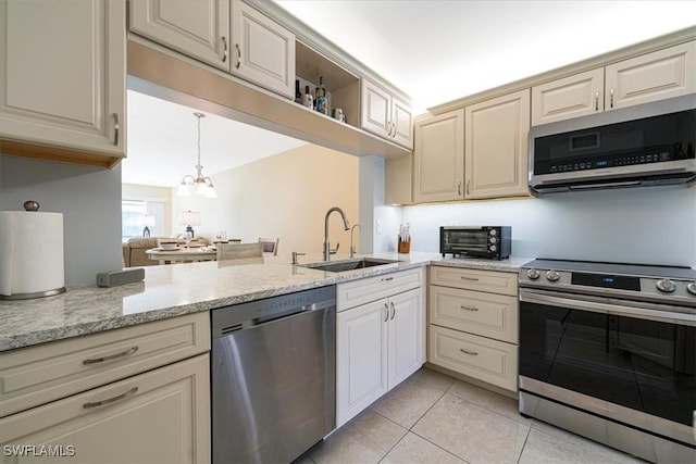 kitchen featuring an inviting chandelier, light tile patterned floors, a sink, a toaster, and stainless steel appliances