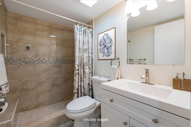 bathroom featuring vanity, toilet, and a tile shower