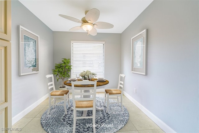 dining area featuring light tile patterned flooring, a ceiling fan, and baseboards