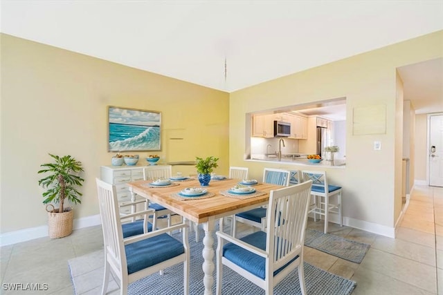 dining area with baseboards and light tile patterned floors