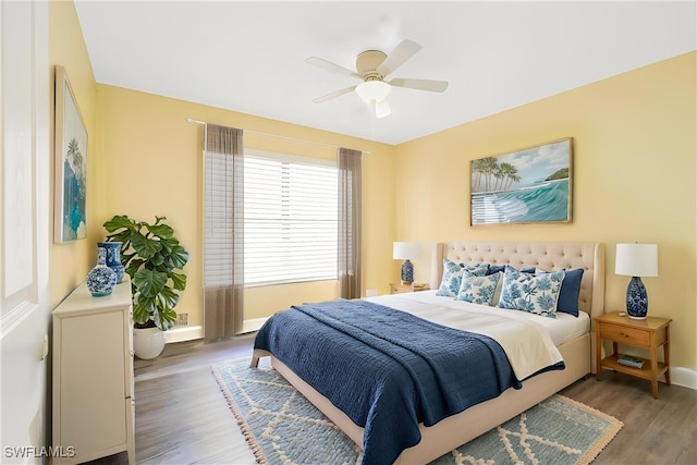 bedroom with ceiling fan, baseboards, and wood finished floors