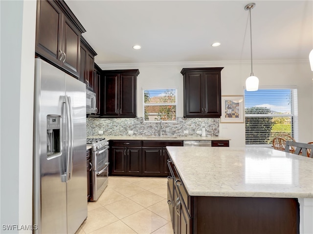 kitchen with sink, a center island, decorative light fixtures, decorative backsplash, and appliances with stainless steel finishes