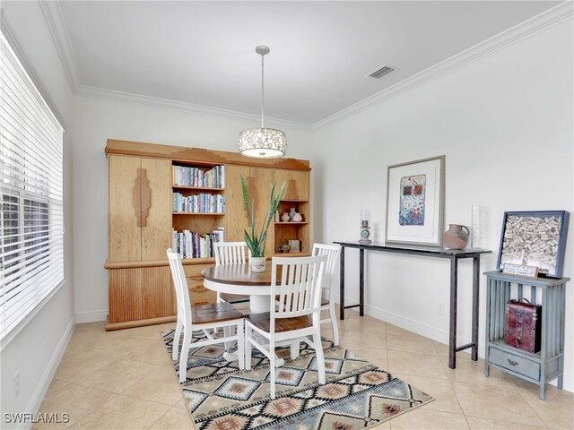 dining space with light tile patterned flooring and ornamental molding