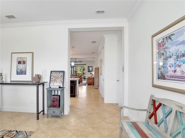 hallway with ornamental molding and light tile patterned flooring