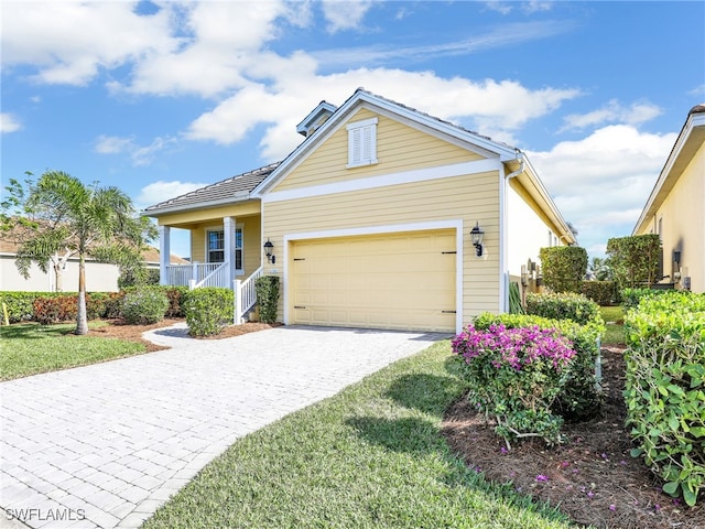 view of front facade with covered porch, a garage, and a front yard