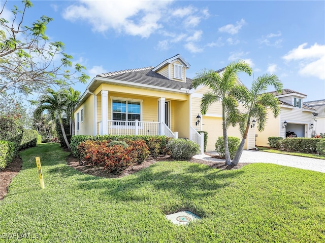 view of front of house featuring a porch, a garage, and a front lawn