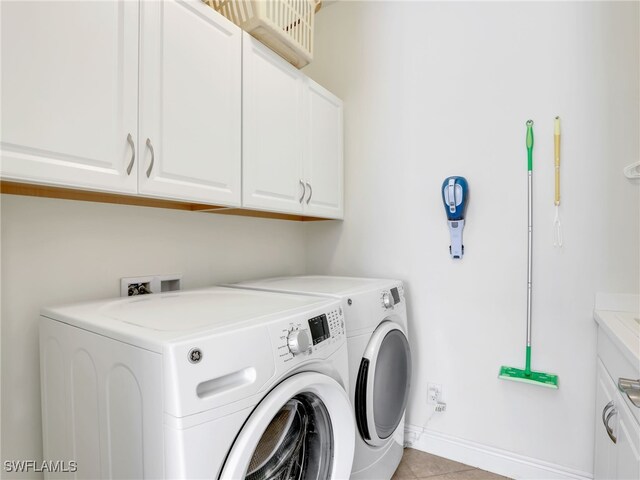 laundry room featuring cabinets, washing machine and dryer, and light tile patterned floors