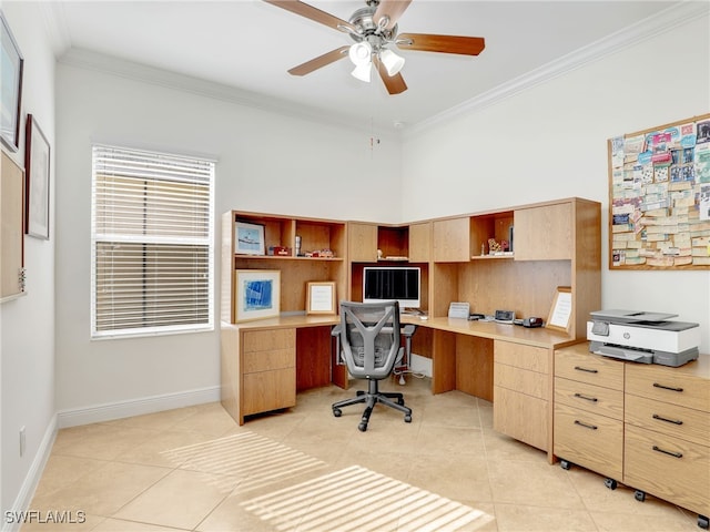 tiled home office featuring a high ceiling, built in desk, ceiling fan, and crown molding