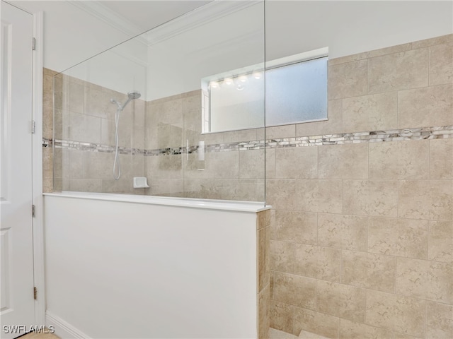 bathroom with crown molding and tiled shower