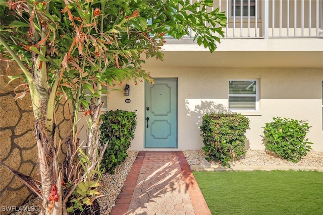 entrance to property with a yard and a balcony