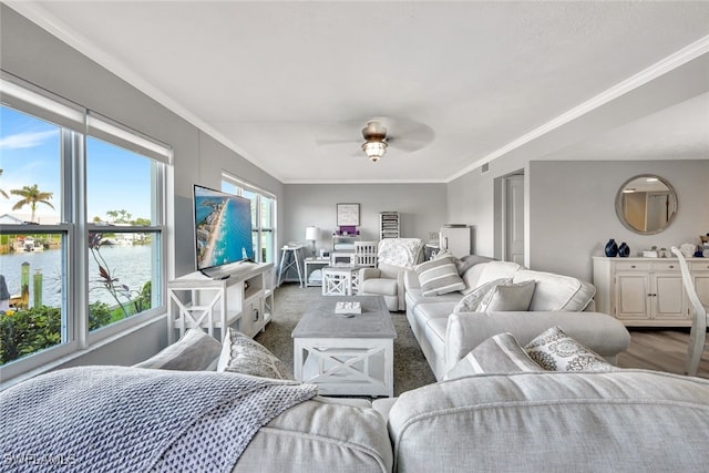 living room featuring ceiling fan, crown molding, and a water view