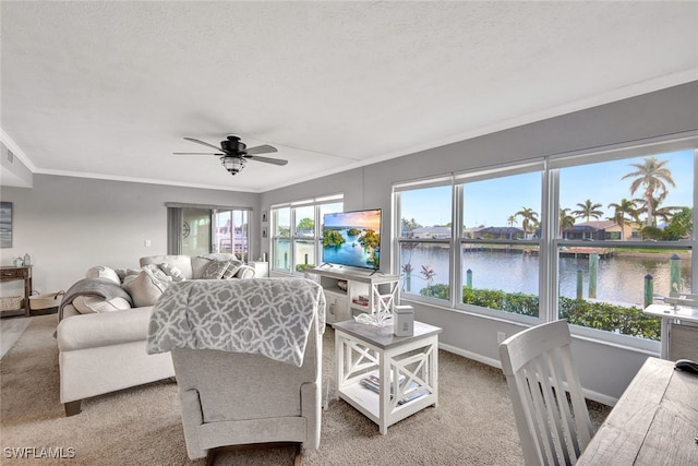 carpeted living room featuring ceiling fan and crown molding